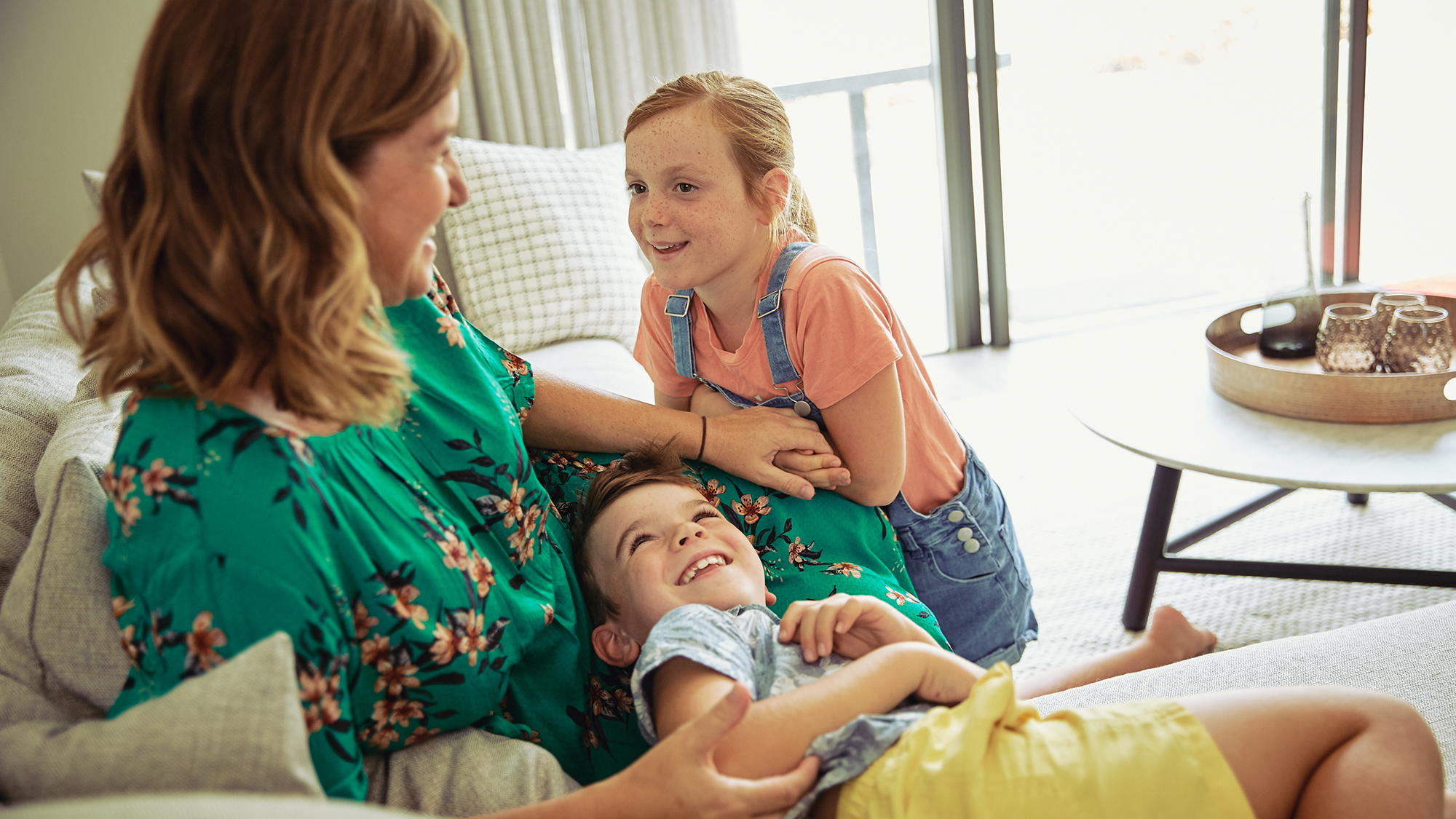 Mother relaxing on couch with kids
